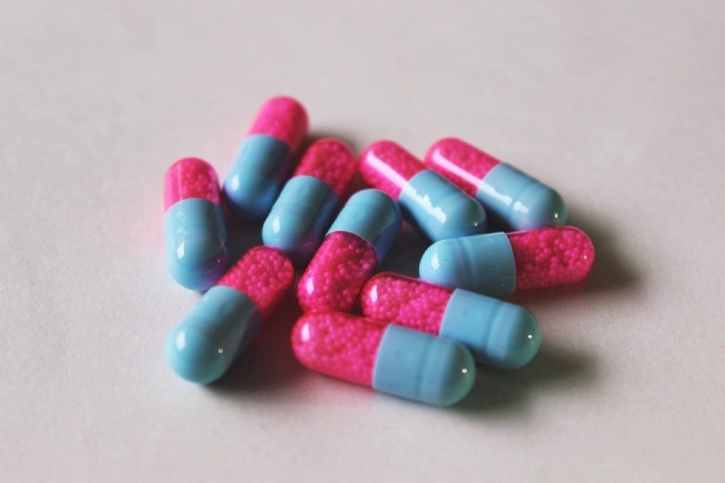 Capsule rosa e azzurre sparse su una superficie chiara